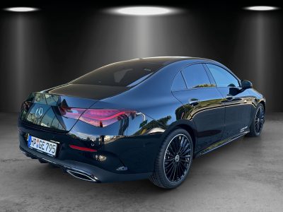 Mercedes-Benz Limousine in Schwarz – Ansicht schräg von hinten rechts. Elegante Karosserie mit fließender Linienführung, abgedunkelte Scheiben, markante LED-Rückleuchten, Doppelendrohr-Abgasanlage, schwarze Mehrspeichen-Leichtmetallfelgen, 4MATIC-Badge