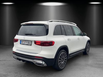 Heckansicht eines weißen Mercedes-Benz SUV bei Nässe, mit LED-Rückleuchten, zwei verchromten Auspuffblenden und getönten Scheiben – aufgenommen im Studio mit Spot-Beleuchtung.