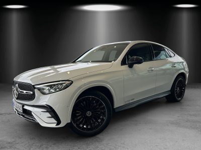 Front- und Seitenansicht eines weißen Mercedes-Benz SUV-Coupés im Studio, mit schwarzen AMG-Leichtmetallfelgen, LED-Scheinwerfern und sportlicher Linienführung.