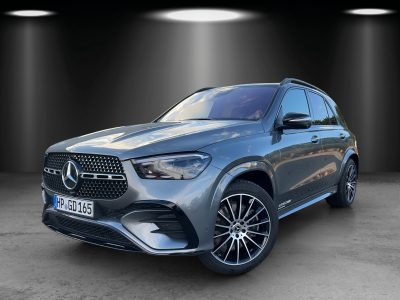 Frontansicht eines grauen Mercedes-Benz GLE SUV mit AMG Line Paket, Diamantgrill, LED-Scheinwerfern und sportlichen Leichtmetallfelgen – Fahrzeug steht in einem ausgeleuchteten Studio.
