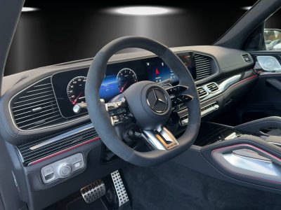 Innenraum eines modernen Fahrzeugs mit digitalem Cockpit, Multifunktionslenkrad und beleuchtetem Armaturenbrett.